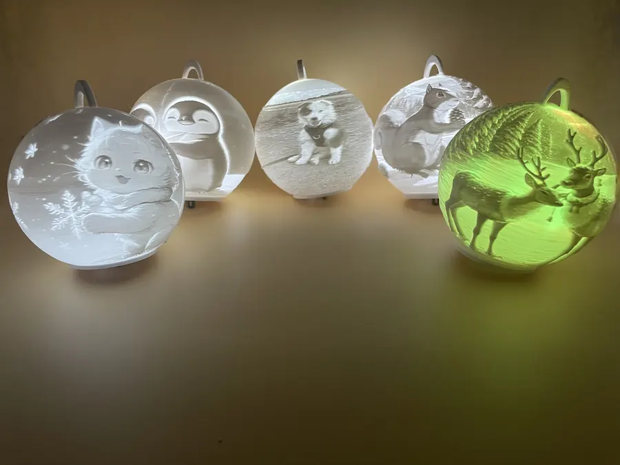 Boule lumineuse décorative imprimée en 3D, motif pingouins, idéale pour Noël ou déco hivernale.