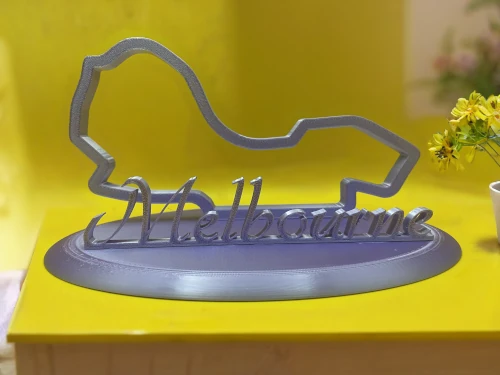 Sculpture décorative imprimée en 3D représentant le tracé du circuit de Melbourne avec le nom du circuit en lettres stylisées sur socle ovale.