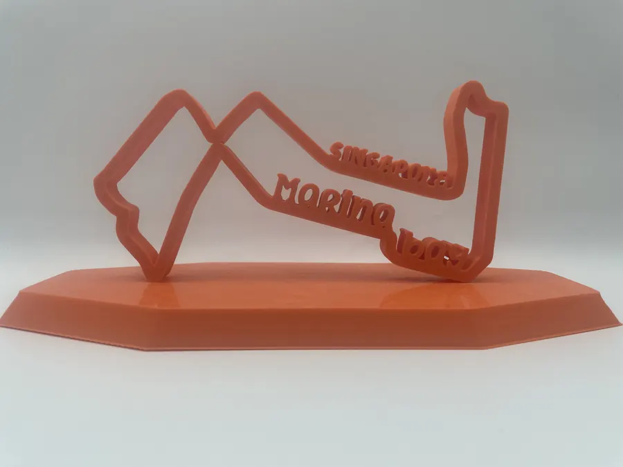 Sculpture décorative imprimée en 3D représentant le tracé du circuit de Marina Bay (Singapour), sur socle octogonal orangé.