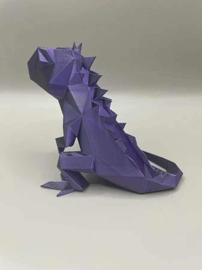 Set de sculptures 3D style low-poly représentant trois lézards/iguane en violet, blanc et vert.