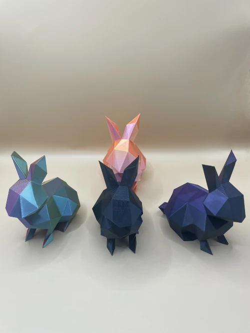 Set de figurines lapins imprimées en 3D, style low-poly, en plusieurs couleurs dégradées.