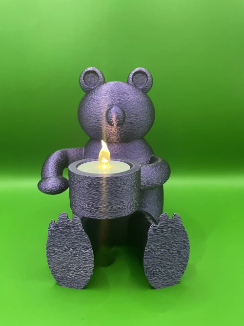 Porte-bougie imprimé en 3D en forme d’ourson assis tenant une bougie LED, finition texturée.