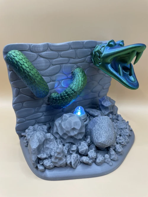 Sculpture murale imprimée en 3D représentant un serpent sortant d’un mur, avec éclairage LED bleu.