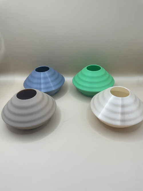 Vase déco imprimé en 3D, forme discoïde aplatie avec surface ondulée, style moderne et minimaliste.