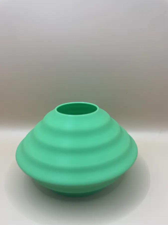 Vase déco imprimé en 3D, forme discoïde aplatie avec surface ondulée, style moderne et minimaliste.
