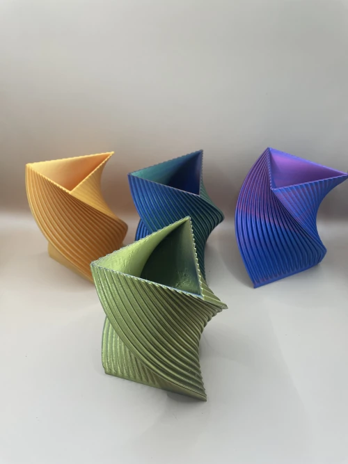 Vase décoratif imprimé en 3D, forme torsadée triangulaire, style moderne et coloré.